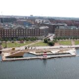 Stedelijk havenbad met zwembassins, kade en stadsgebouwen