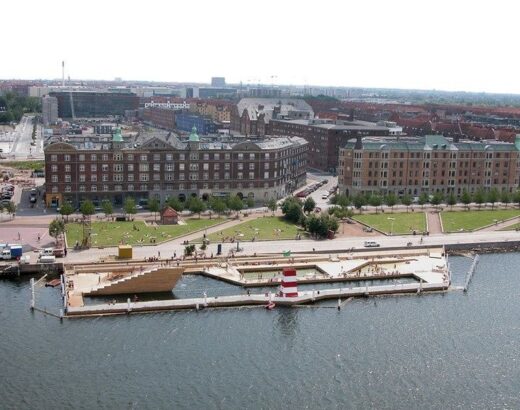 Stedelijk havenbad met zwembassins, kade en stadsgebouwen
