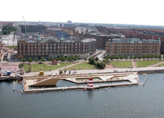 Stedelijk havenbad met zwembassins, kade en stadsgebouwen